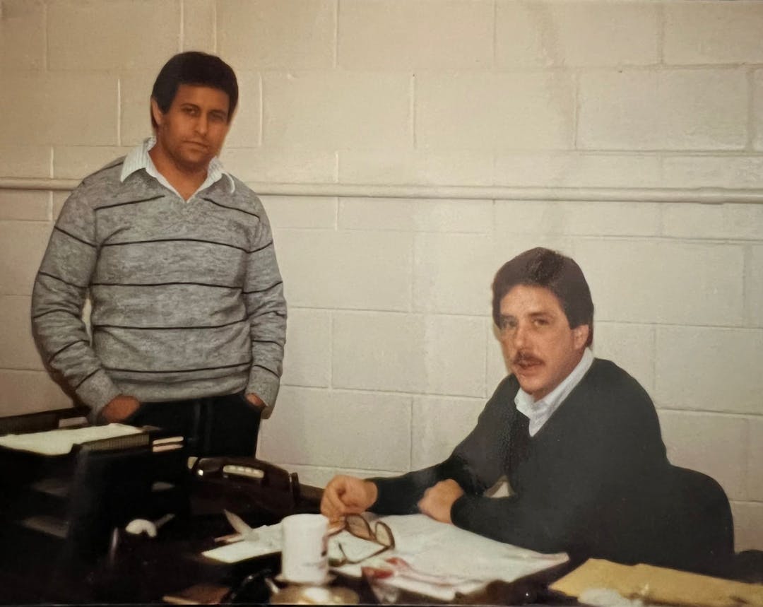 Founders of Javco when younger at a desk discussing business